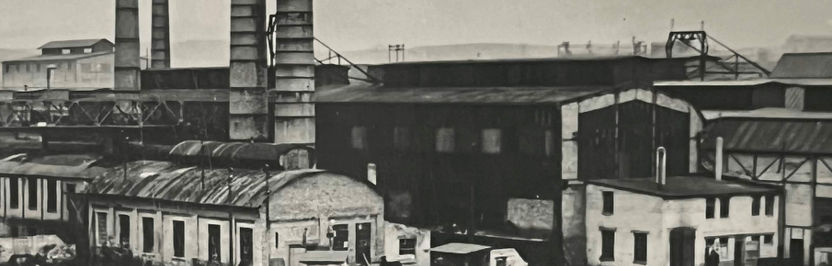 historic black and white photo of the outside of steel production site.