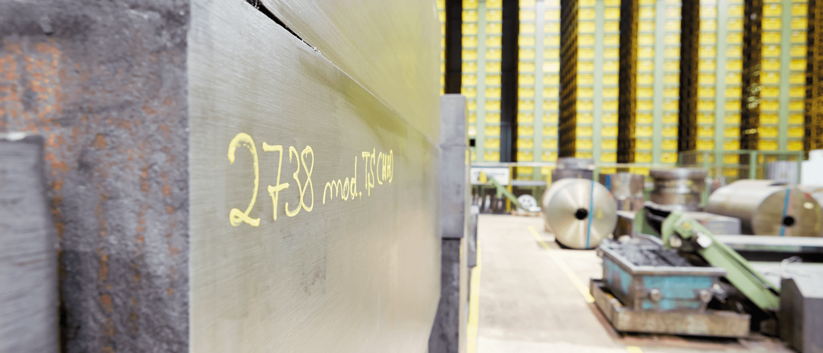 storage area at a production site where steel slabs and rolls of stainless steel can be seen