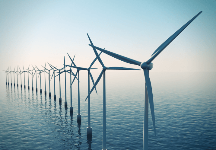 a row of windmills in a body of water