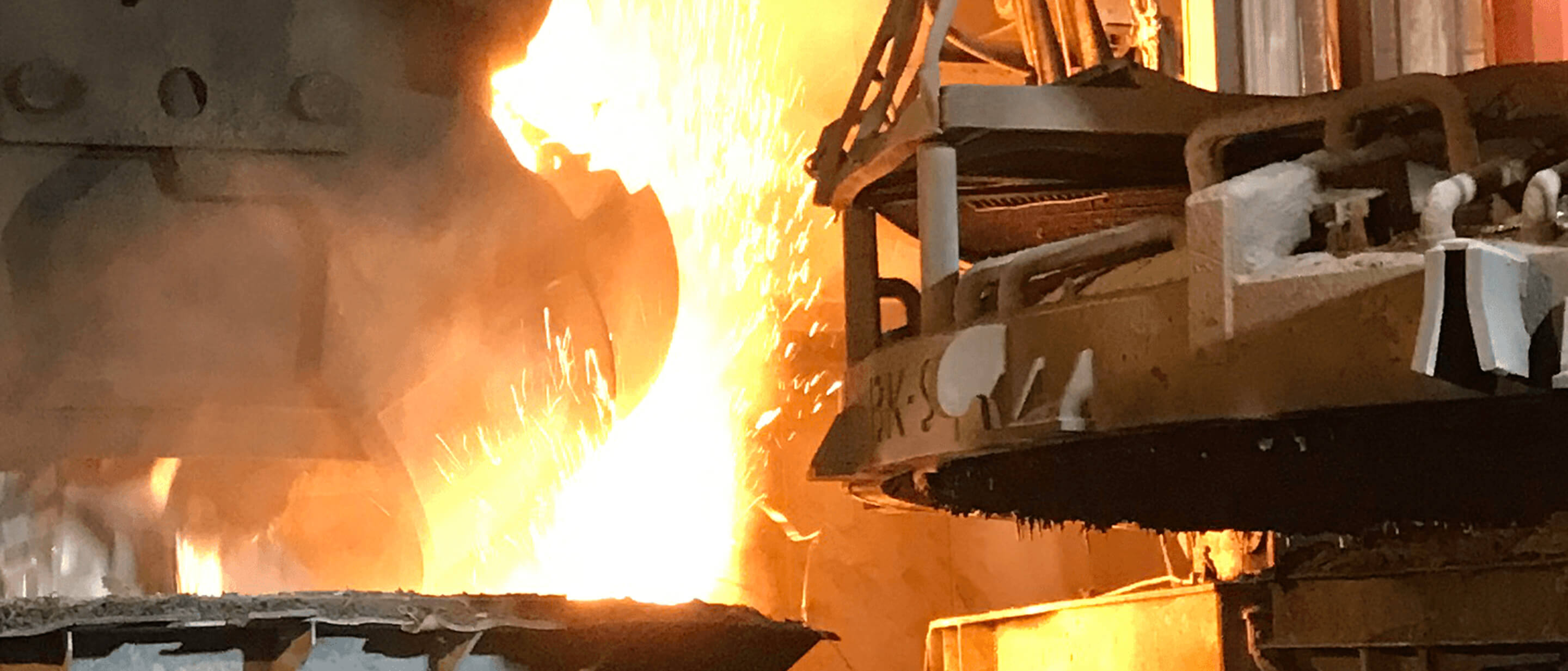 Photo depicting the charging of the E-oven in the steel production process